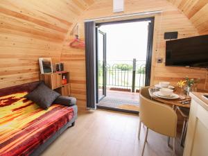 a room with a bed and a table and a television at Sunset Pod in Shrewsbury