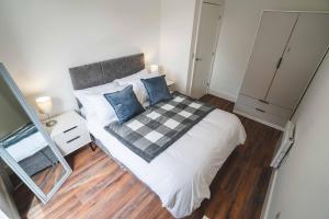 a small bedroom with a bed with a checkered blanket at Modern 1-Bed Apartments - New - City Centre - FREE Wi-Fi - in Sheffield