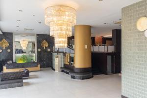 un vestíbulo con una gran lámpara de araña en un edificio en Boss Suites Nana Hotel en Bangkok