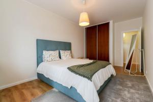 une chambre avec un grand lit et une tête de lit bleue dans l'établissement Da Silva House - Ap in Afife with Balcony & SeaView, à Viana do Castelo