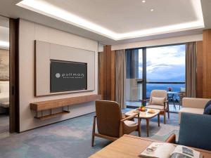 a hotel room with a television and a living room at Pullman Yuxi in Yuxi
