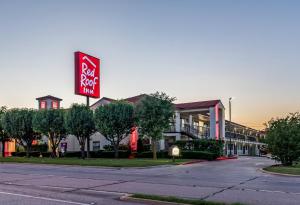 a sign for a hotel on the side of a street at Red Roof Inn Dallas - Mesquite Fair Park NE in Mesquite