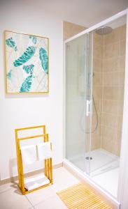 baño con ducha y puerta de cristal en Monti-love en Montivilliers