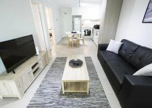 ein Wohnzimmer mit einem schwarzen Sofa und einem Couchtisch in der Unterkunft Yaran Suites in Rockingham