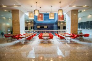 restauracja z czerwonymi krzesłami i stołami w budynku w obiekcie Andersia Hotel & Spa Poznan, a member of Radisson Individuals w Poznaniu