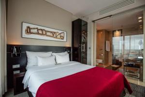 ein Schlafzimmer mit einem großen Bett mit einer roten Decke in der Unterkunft Andersia Hotel & Spa Poznan, a member of Radisson Individuals in Posen