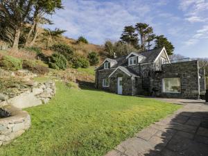 a stone house on a hill with a yard at Ceilwart Cottage in Barmouth