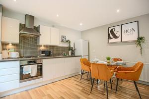 a kitchen and dining room with a table and chairs at Campbell Park Apartment - City Centre - Free Parking, Balcony, Super-Fast Wifi and Smart TV with Netflix by Yoko Property in Milton Keynes
