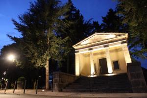 a white building on steps at night at Hotel Le Comty in Feurs