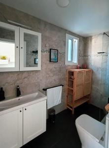 a bathroom with a white sink and a toilet at Villacarmen Suite in Benalmádena