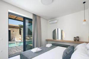 a bedroom with a bed and a swimming pool at Ikritis Villas in Chorafakia