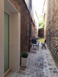 une allée avec deux chaises et une table à côté d'un bâtiment dans l'établissement LA FORTERESSE - Jacuzzi/Sauna - Centre Historique, à Rouen