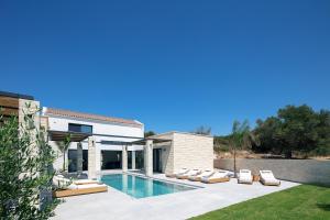 a villa with a swimming pool and lounge chairs at Ikritis Villas in Chorafakia +123 photos