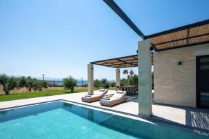 a villa with a swimming pool and a patio at Ikritis Villas in Chorafakia