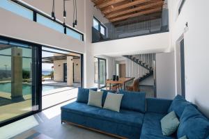 una sala de estar con un sofá azul en una casa en Ikritis Villas, en Chorafakia