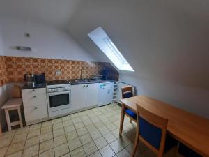 a kitchen with white appliances and a wooden table at Ferienwohnung StrandGut in Burhave
