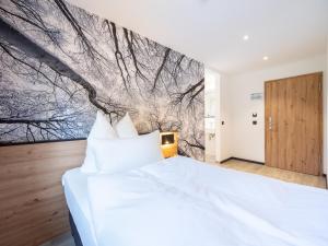 ein Schlafzimmer mit einem weißen Bett und einem Gemälde an der Wand in der Unterkunft Gasthof Wisonbrona in Sankt Vith