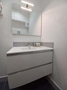 La salle de bains est pourvue d'un lavabo blanc et d'un miroir. dans l'établissement Little Rose Haven, à Rome