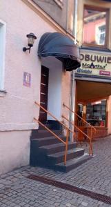 a building with a staircase in front of a store at Apartament Po schodkach in Duszniki Zdrój