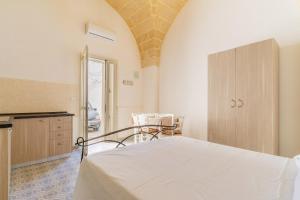 een slaapkamer met een bed, een kast en een tafel bij Casa Emi by BarbarHouse in Veglie