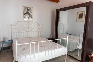 a bedroom with a white crib and a mirror at Casale Carratois - casa vacanze - Marzameni - Noto in Portopalo
