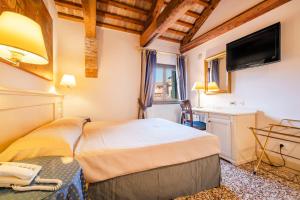 a hotel room with a bed and a television at Hotel Bella Venezia in Venice