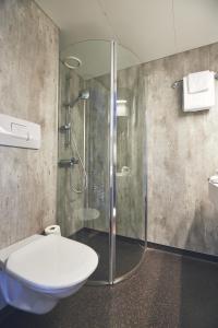 a bathroom with a glass shower and a toilet at Hotel Frøya in Sistranda