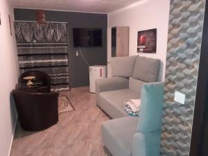 a living room with a couch and a tv at Luxuries Beta in Saturn