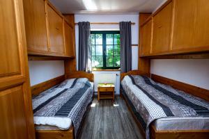 Prijeten sončen apartma v objemu Pohorja في Zgornje Hoče: سريرين في غرفة صغيرة مع نافذة