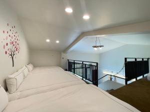 una camera da letto con un grande letto bianco in una stanza di Jabez II a Jiaoxi