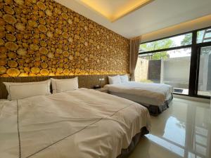 1 dormitorio con 2 camas y una pared de troncos en Jabez II, en Jiaoxi