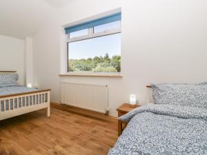 a bedroom with two beds and a window at Steel Works Farm in Ross on Wye