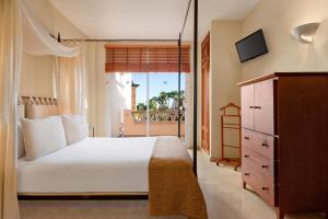 a bedroom with a large white bed and a balcony at Wyndham Residences Costa del Sol in Fuengirola