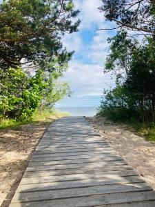 a wooden path leading down to the beach at Pie Oskara in Kolka