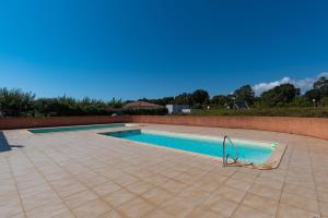 een zwembad met een tegelvloer bij Torra Mare in Cervione