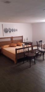 um quarto com uma cama com duas cadeiras e duas mesas em Appartamento Poggio Biondo em Buriano