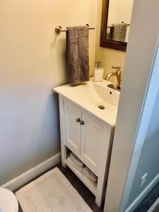 y baño con lavabo blanco y espejo. en Sauble Shores Waterfront Hideaway, en Sauble Beach