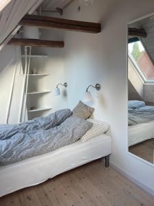a bedroom with a bed and a mirror at Aabels in Sæby
