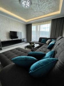 uma sala de estar com um sofá grande e almofadas azuis em Apartmány Residence em Donovaly
