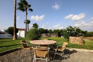 een patio met een tafel en stoelen in een tuin bij TESS Villa Le Clos Fleury in Alhaurín de la Torre