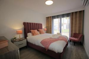 una camera da letto con un grande letto con una grande finestra di TESS Villa Le Clos Fleury ad Alhaurín de la Torre