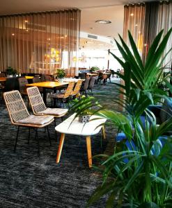ein Restaurant mit Tischen, Stühlen und Pflanzen in der Unterkunft Future Inn Cardiff Bay in Cardiff
