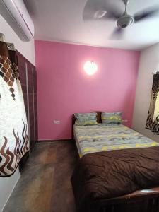 a bedroom with a bed and a purple wall at Coral Drive Villas -Your Private Beach Destination in Chennai