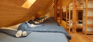 a row of beds in a room with wooden ceilings at Hostel Borik in Ðurđevac