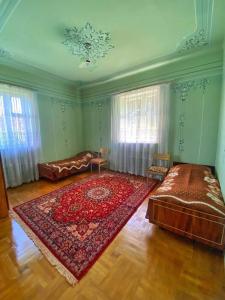 un soggiorno con un grande tappeto rosso sul pavimento di Guest House a Sevan