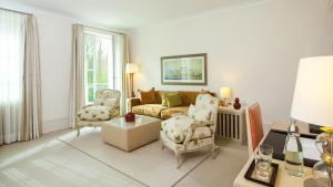 ein Wohnzimmer mit einem Sofa und 2 Stühlen in der Unterkunft Grand Hotel Heiligendamm - The Leading Hotels of the World in Heiligendamm