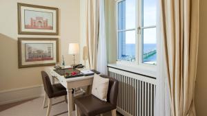 ein Hotelzimmer mit einem Schreibtisch und einem Fenster in der Unterkunft Grand Hotel Heiligendamm - The Leading Hotels of the World in Heiligendamm