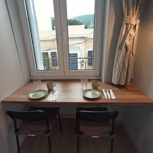 uma mesa num quarto com duas cadeiras e uma janela em Vecchio em Lepanto