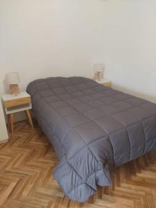 un letto con piumone blu in una camera da letto di SOHO PETIT STUDIO - EXCELENTE UBICACIÓN - Súper cómodo, completo - PALERMO a Buenos Aires