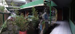 Ein Gebäude mit Pflanzen im Garten. in der Unterkunft Liemas hotel in Pasuruan
